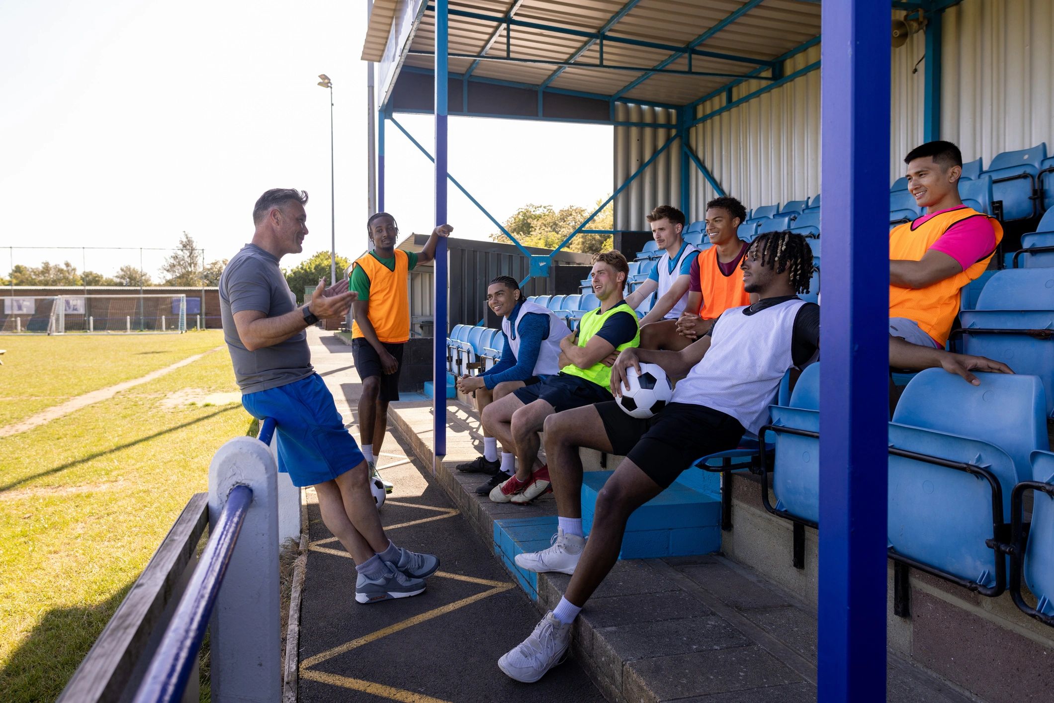 Youth athletes listening to a coach during a team talk